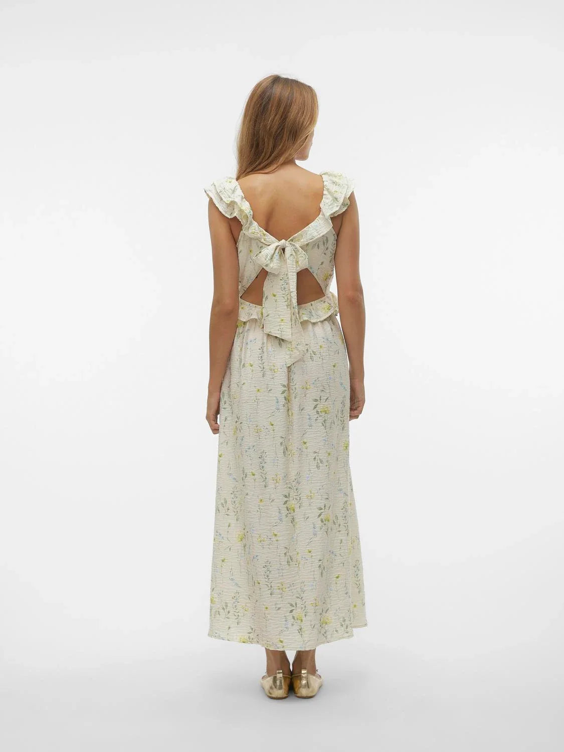 Back full length view of vintage-inspired botanical print dress with romantic frill neckline and graceful flowing fit.