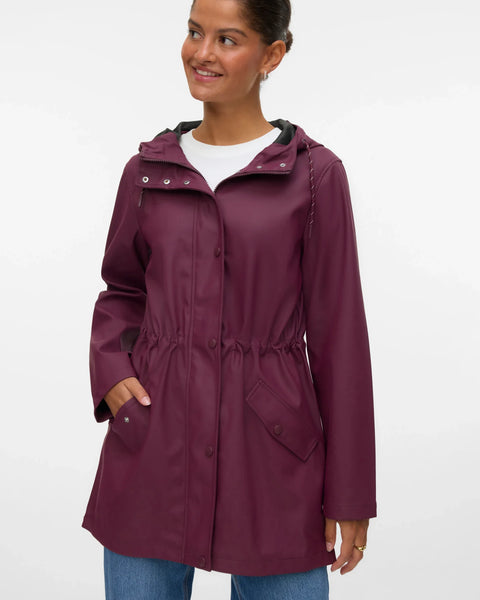 Women’s burgundy hooded raincoat with adjustable drawstring waist, front pockets, and snap closure for stylish rainy-day outfits.