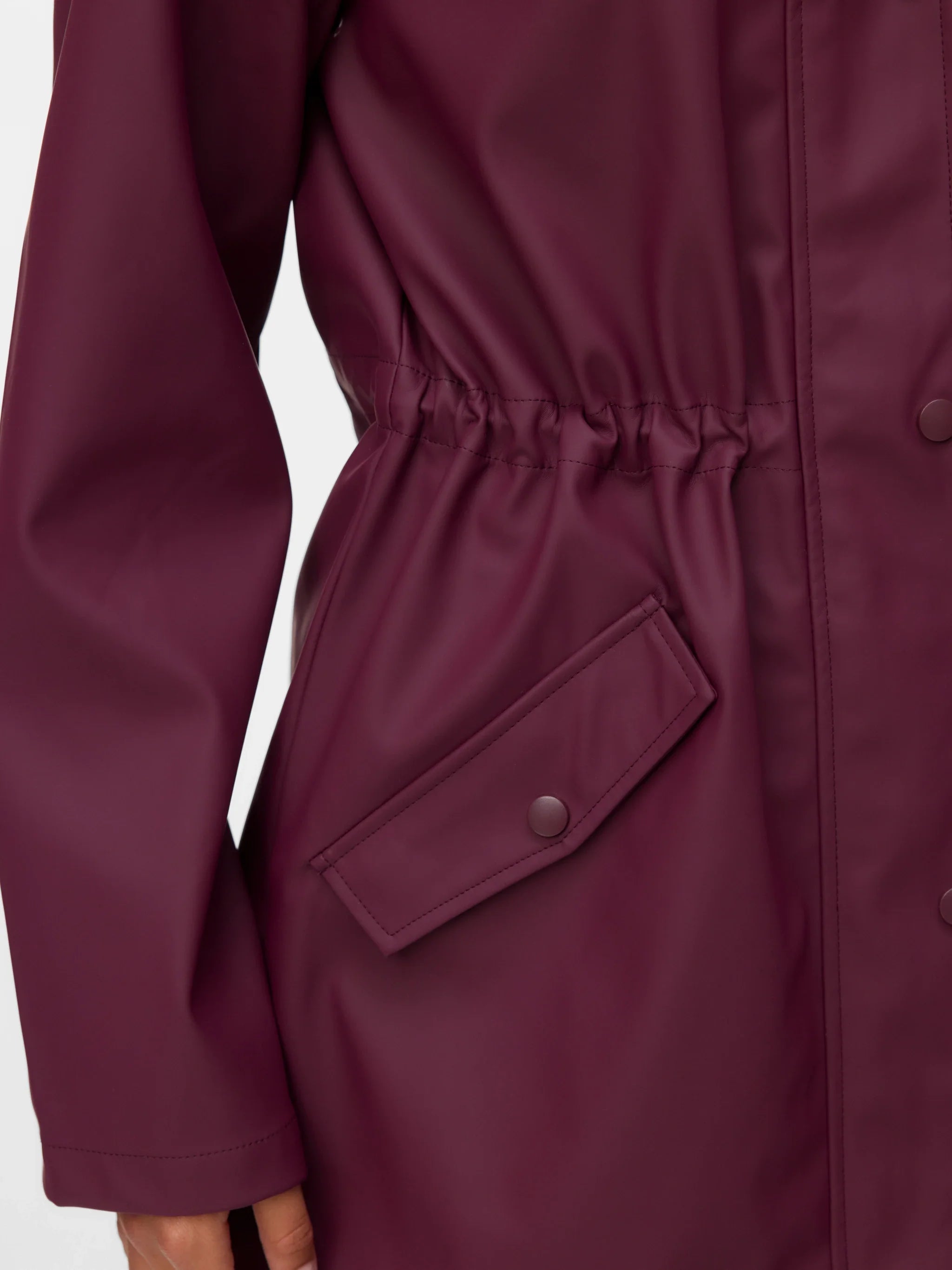 Detail of luxe everyday raincoat with adjustable waist and contemporary Scandinavian-inspired style.