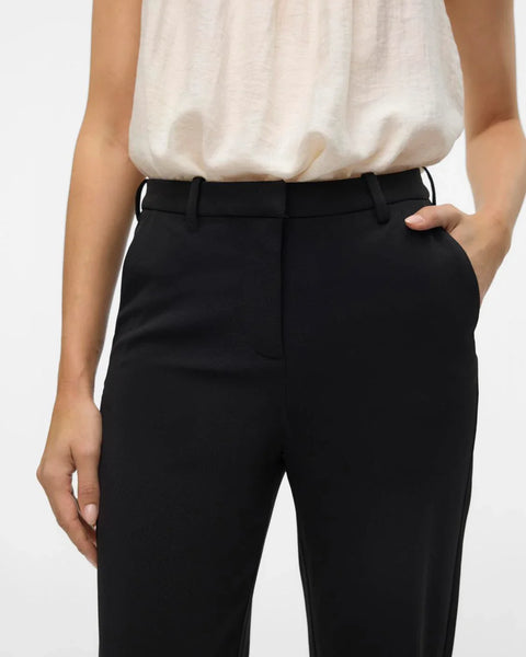 Women’s high-waisted black trousers with wide leg design and timeless professional chic fashion look.