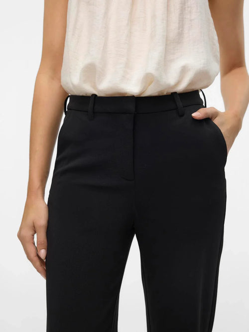 Women’s high-waisted black trousers with wide leg design and timeless professional chic fashion look.