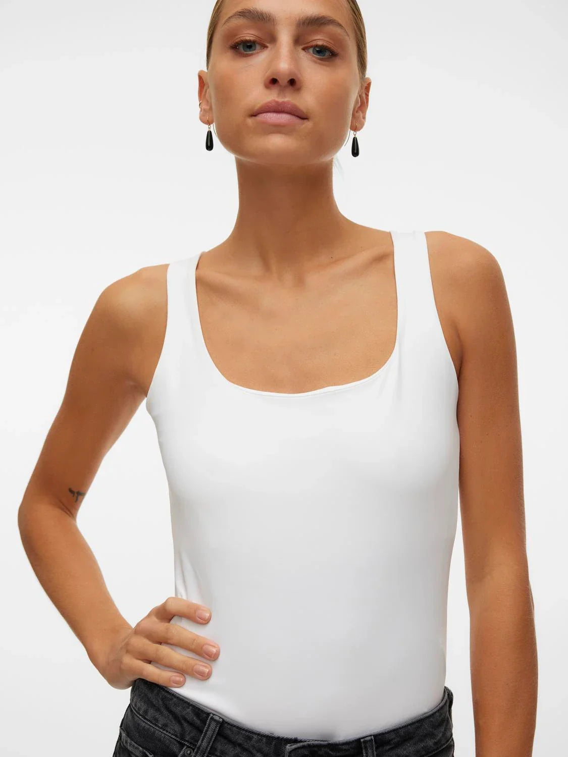 Elevated basic white tank top featuring a fitted silhouette and clean luxury-inspired everyday style.