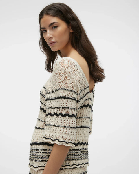 Cream and black open knit top with feminine scalloped stripe accents and contemporary bohemian-inspired silhouette.