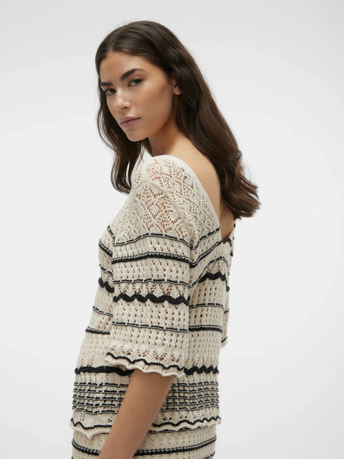 Cream and black open knit top with feminine scalloped stripe accents and contemporary bohemian-inspired silhouette.