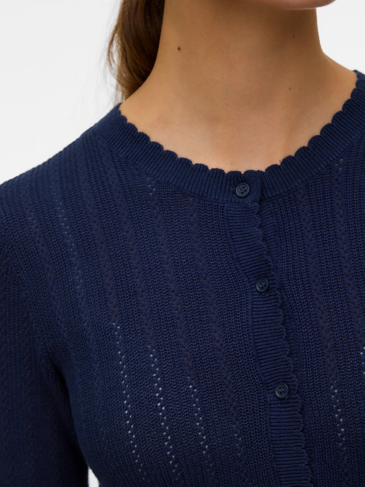 Elegant women's navy blue crew neck cardigan featuring delicate knit texture, tonal buttons and scalloped trim for polished layering.