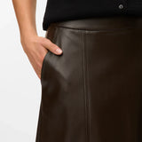 Women’s dark brown faux leather midi skirt with A-line silhouette and panel seam detailing for chic fall outfits.