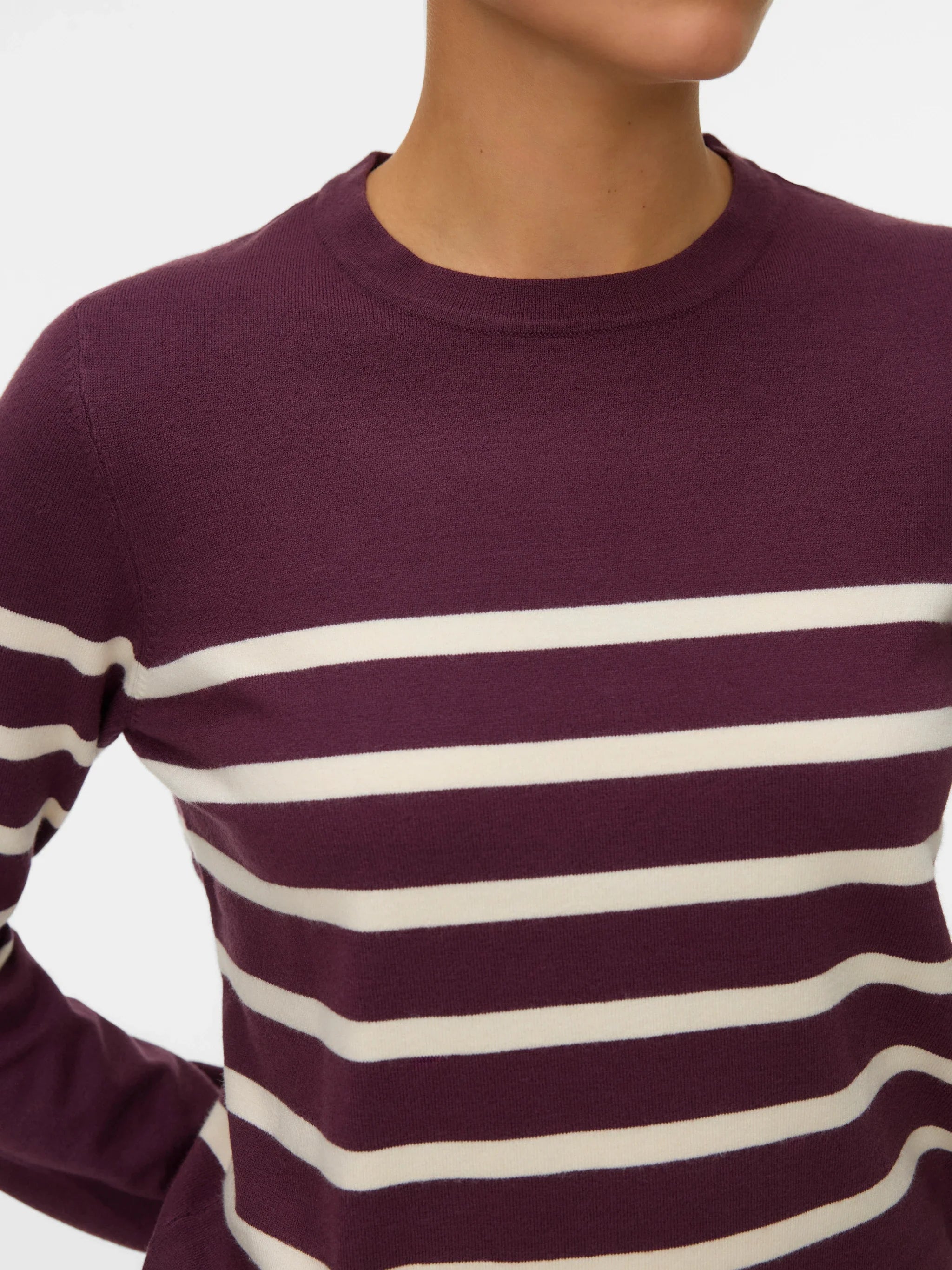 Close up of modern collegiate-inspired knitwear in rich aubergine and soft cream tones