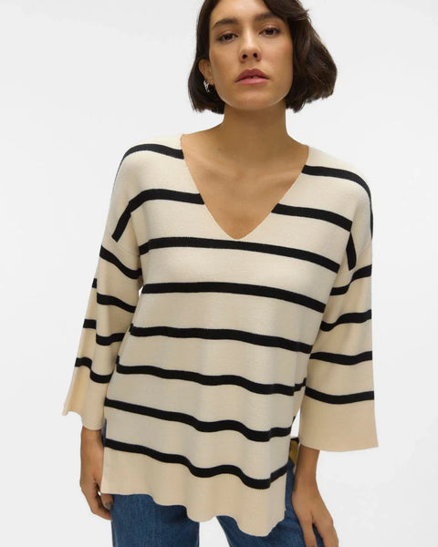 Oversized cream knit sweater with bold black stripes and relaxed silhouette for timeless chic streetwear-inspired style.