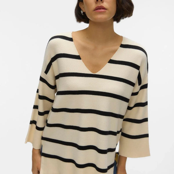 Oversized cream knit sweater with bold black stripes and relaxed silhouette for timeless chic streetwear-inspired style.