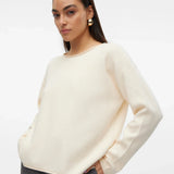 Minimalist creme-colored long sleeve knit sweater with soft texture and elevated casual boutique fashion aesthetic.