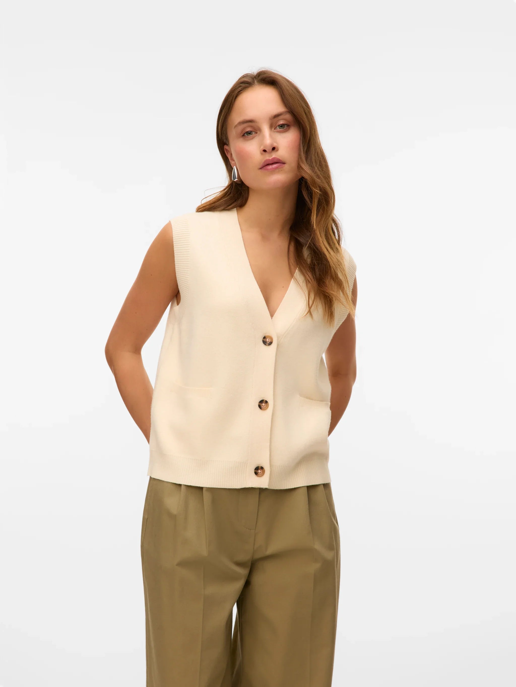 Women’s ivory sleeveless knit cardigan vest with buttons for minimalist smart casual outfits.