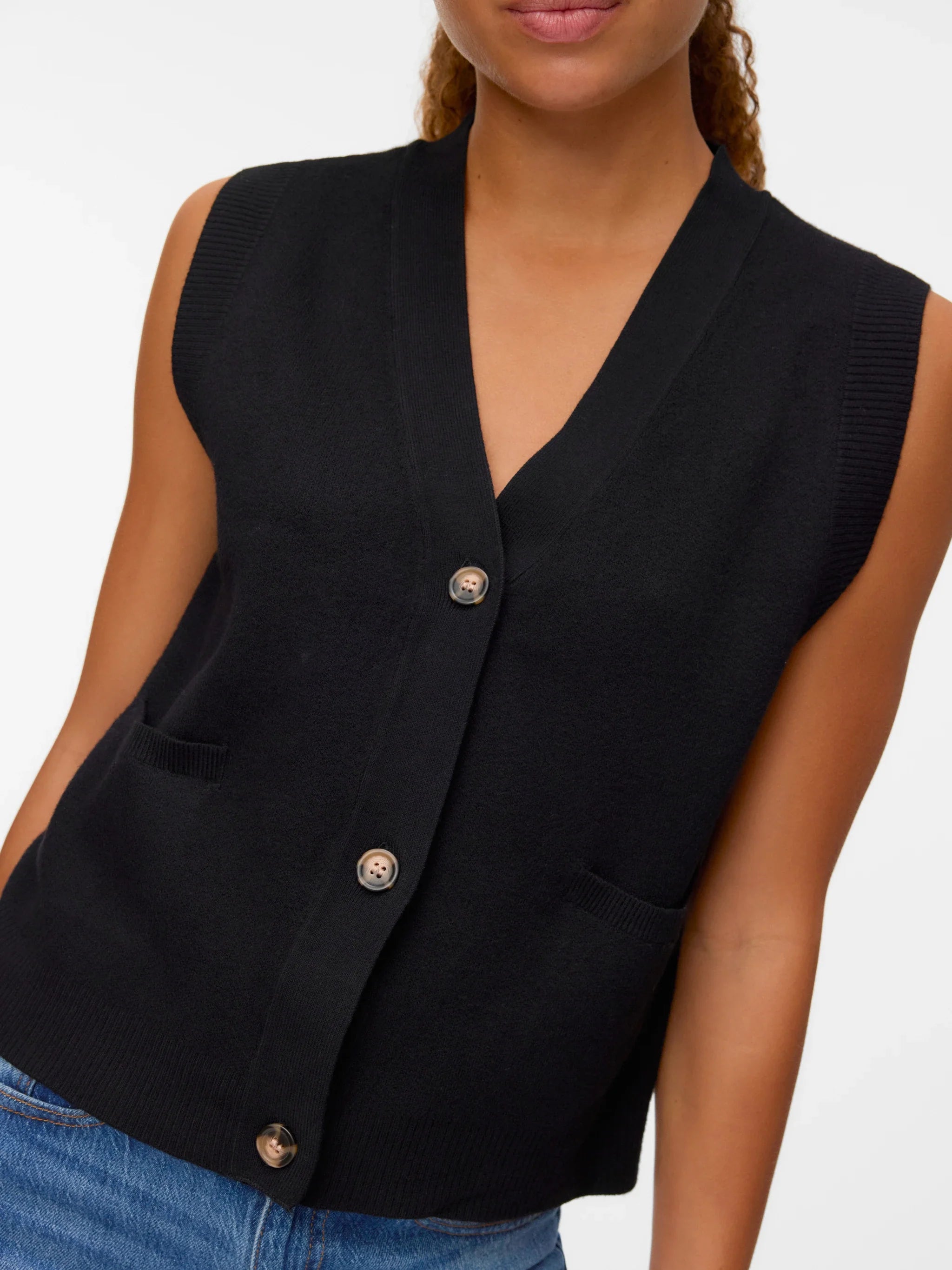 Women’s black knit waistcoat with V-neck, front buttons, and patch pockets for elevated minimalist fashion.