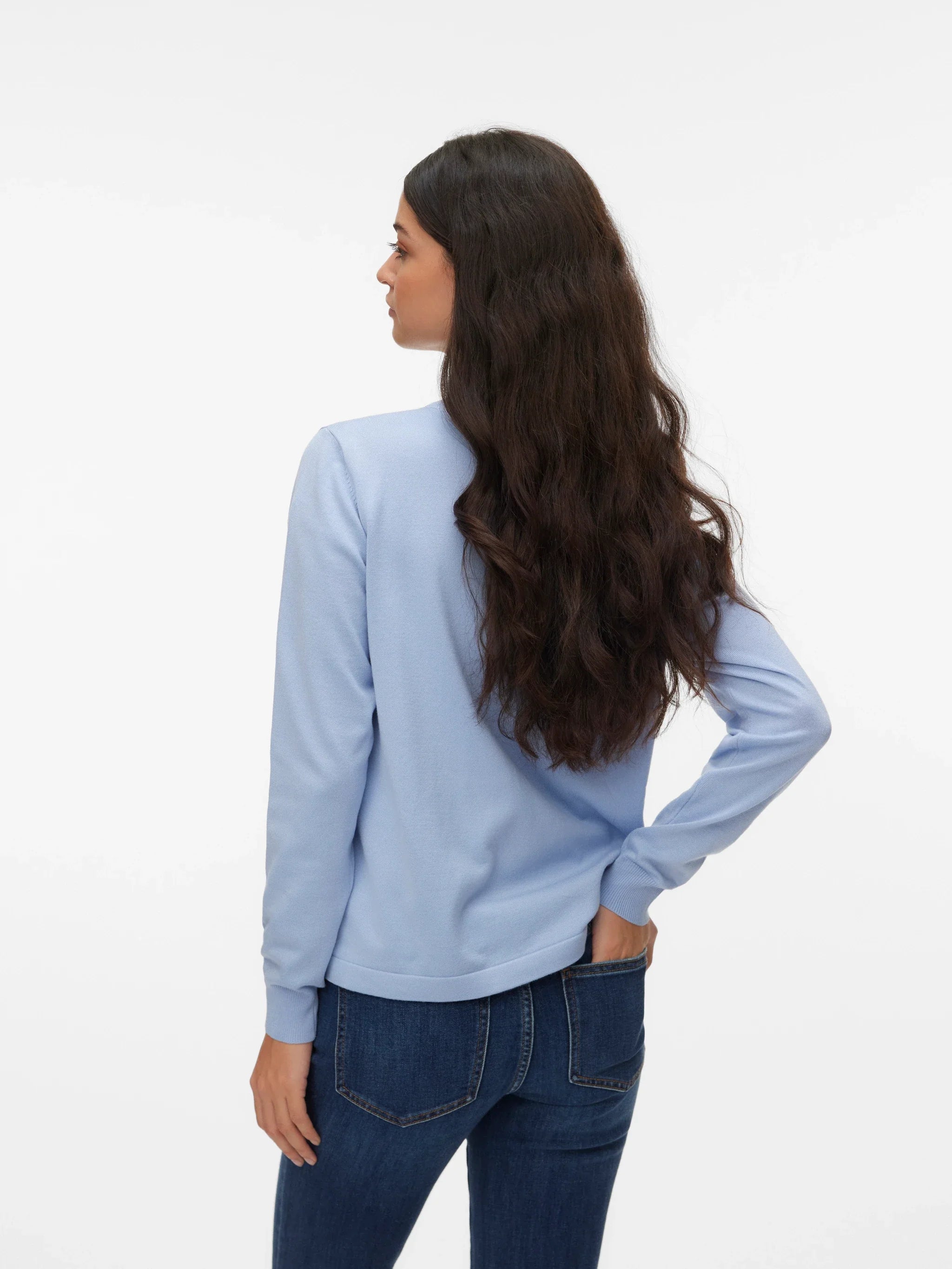 Light blue women's knit pullover with crew neck, ribbed cuffs and relaxed silhouette styled with dark wash jeans.
