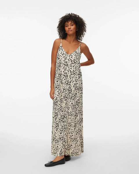 Relaxed fit spotted maxi dress featuring delicate spaghetti straps, full-length drape, and sophisticated neutral tones for travel and holiday wardrobes.