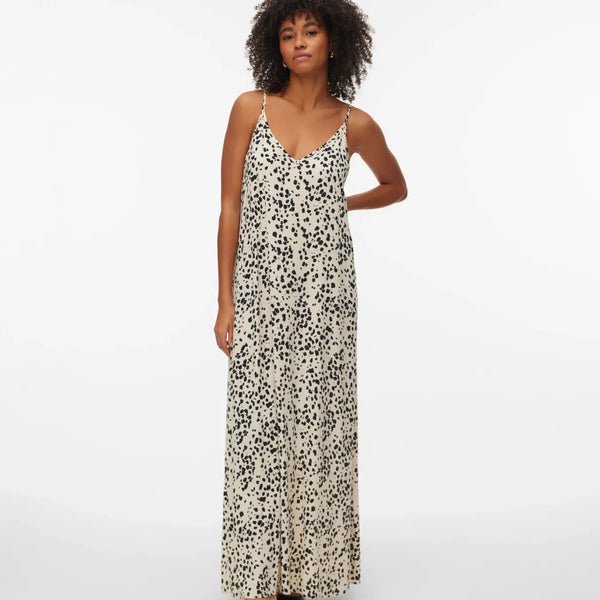 Relaxed fit spotted maxi dress featuring delicate spaghetti straps, full-length drape, and sophisticated neutral tones for travel and holiday wardrobes.